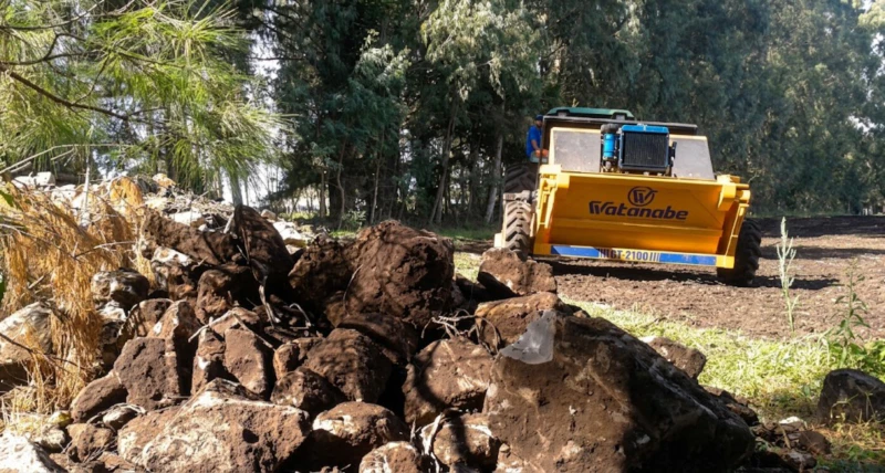CT-2100 Rock Picker collecting stones on agricultural land – bunker hopper filling with stones during picking operation